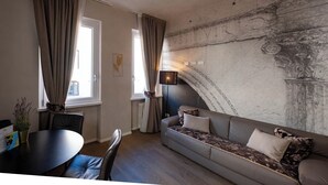 Ein modernes Wohnzimmer mit einer Couch, einem Esstisch und einer Lampe.