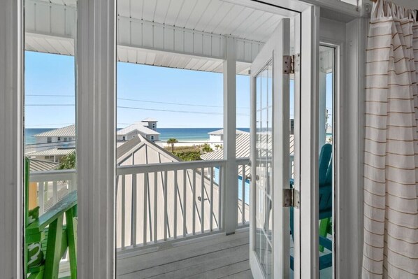 A balcony with a view of the beach and ocean.