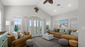 A spacious living room with two sofas, a coffee table, and a fireplace. - Sea-Jay ~ Dog-Friendly Gulf View Retreat, Steps to Beach & Pier Park (Panama City Beach)