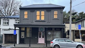 A two-story building with a dark facade and multiple windows. - Tinakori Village Retreat - 
Renovated apartment in a charming heritage building (Wellington)