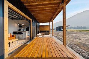 Relax in this open-plan living space with a spacious kitchen, dining area, and outdoor deck.