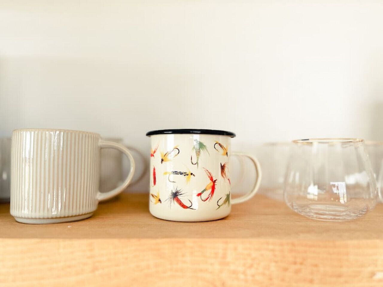 Three ceramic mugs on a wooden surface.