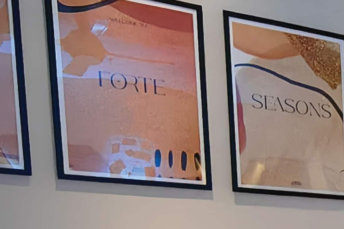 Un lit bien fait, avec du linge de lit blanc, dans une chambre d'hôtel.