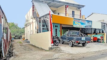 A building with a sign for 'Home Stay Surga' and a parked truck.
