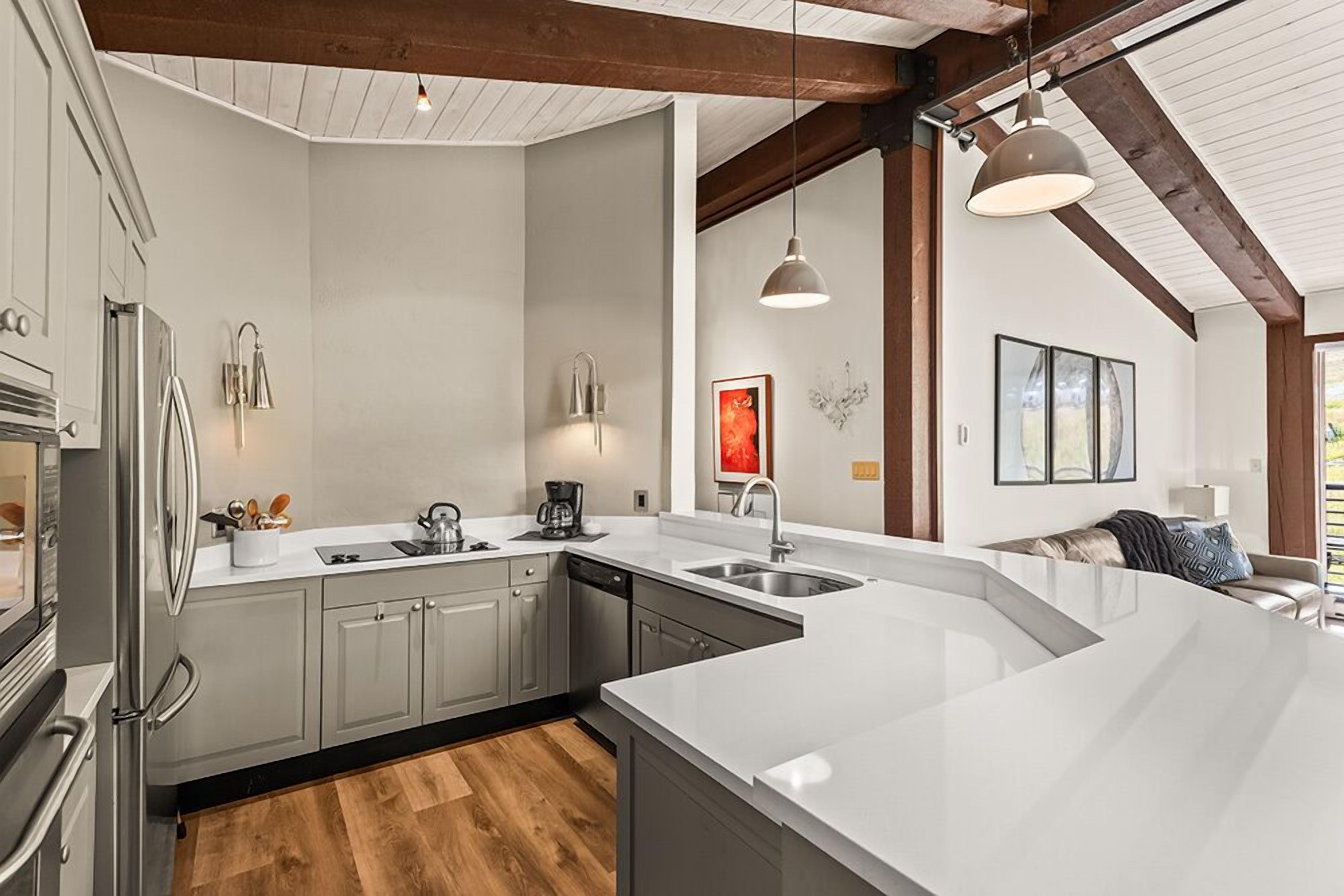 A modern kitchen with a large island, built-in appliances, and pendant lighting.