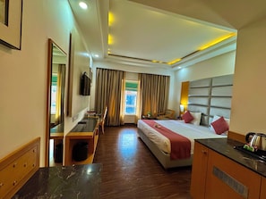 Relax in this stylish room with a large bed, desk, and TV, perfect for a comfortable stay.