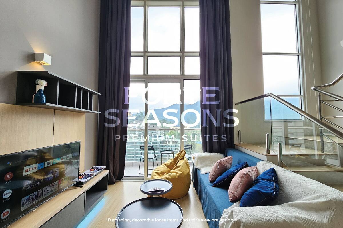 A modern living room with a large TV, a sofa, a coffee table, and a view of the city through large windows.