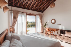 Un dormitorio con una cama grande, un escritorio y un sofá.