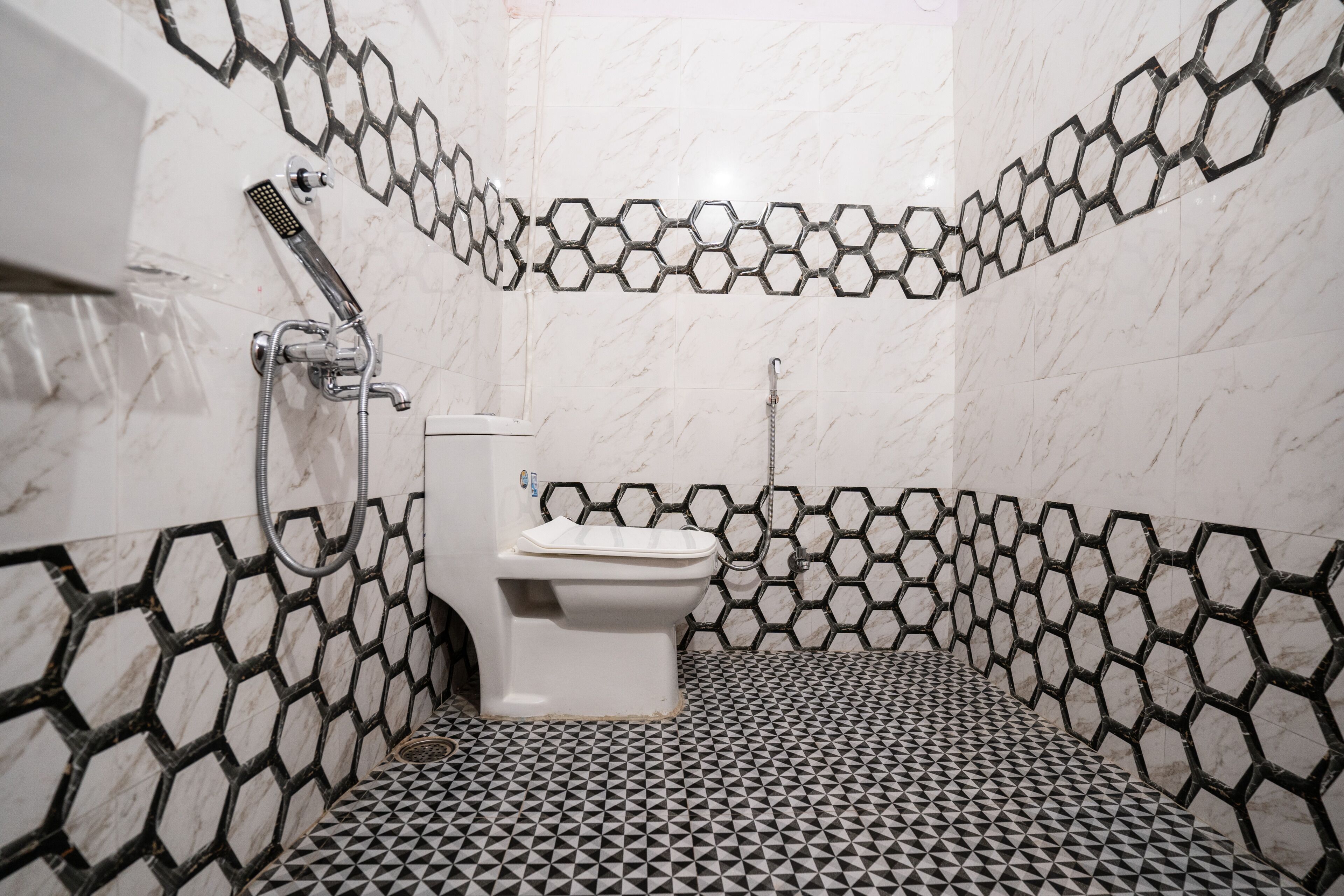 A bathroom with a toilet, a shower, and a sink.