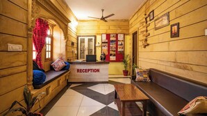 Uma área de recepção com balcão de check-in, assentos e uma parede com quadros emoldurados.