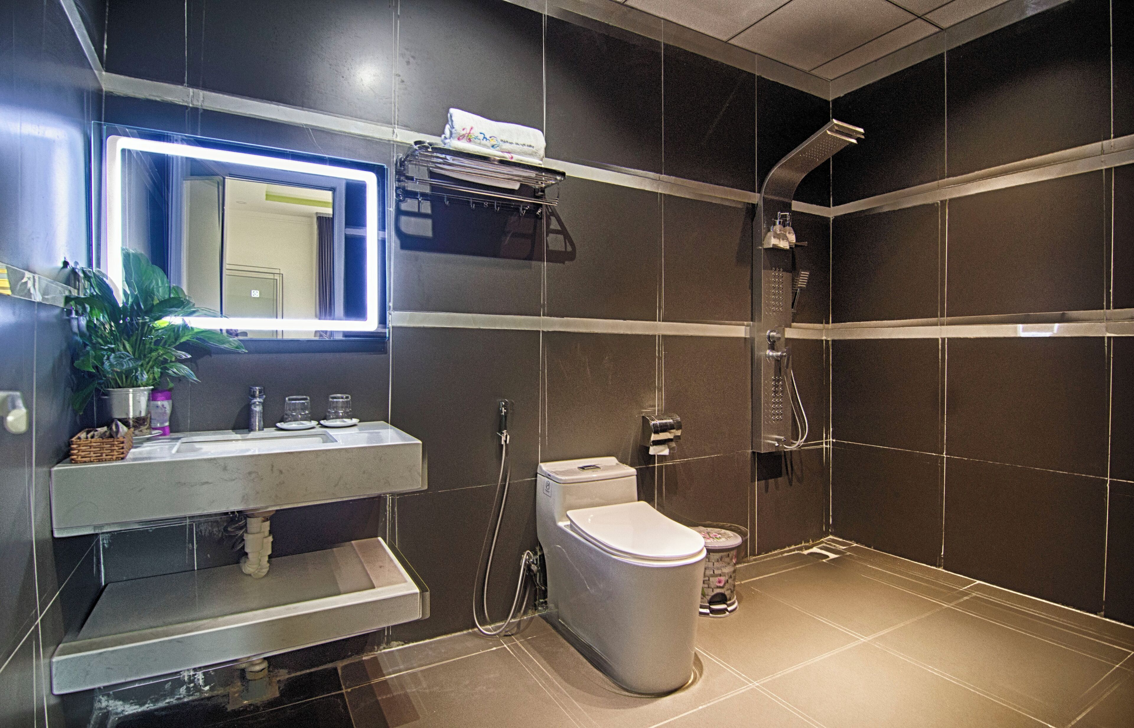 A modern bathroom with a toilet, sink, and shower.