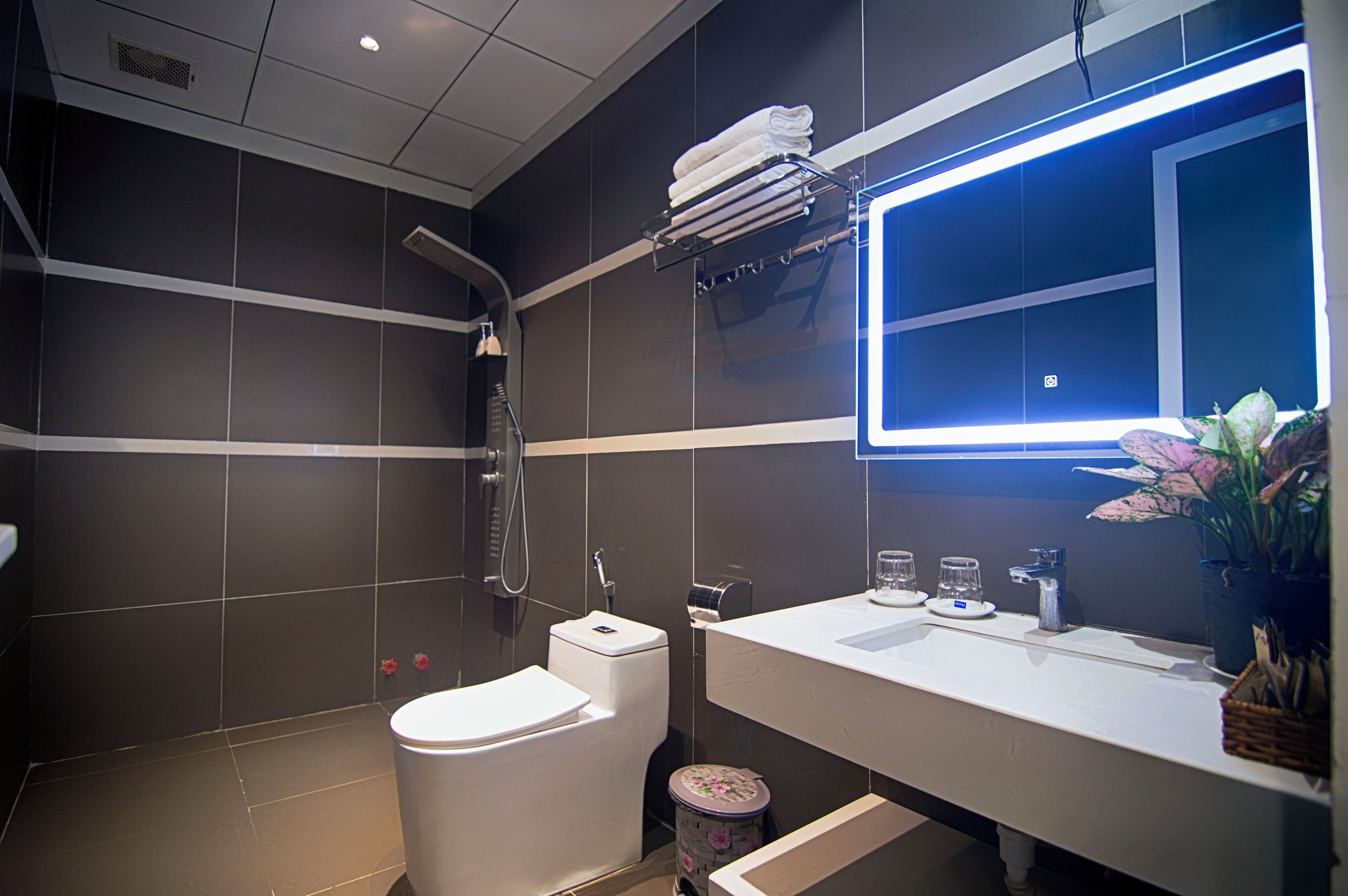 A modern bathroom with a toilet, sink, and shower.