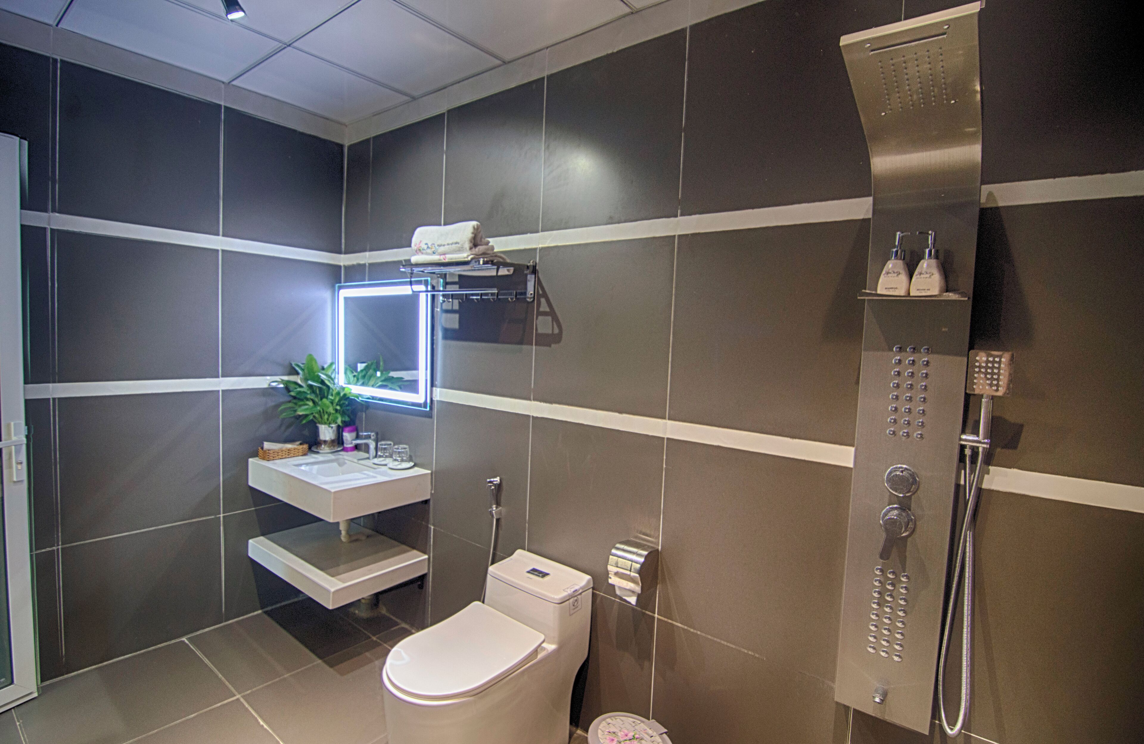 A modern bathroom with a toilet, sink, and shower.