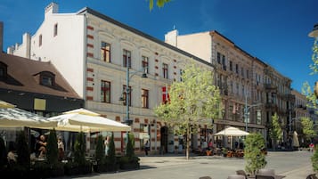 An outdoor café area with tables and chairs, surrounded by buildings with classical architecture.