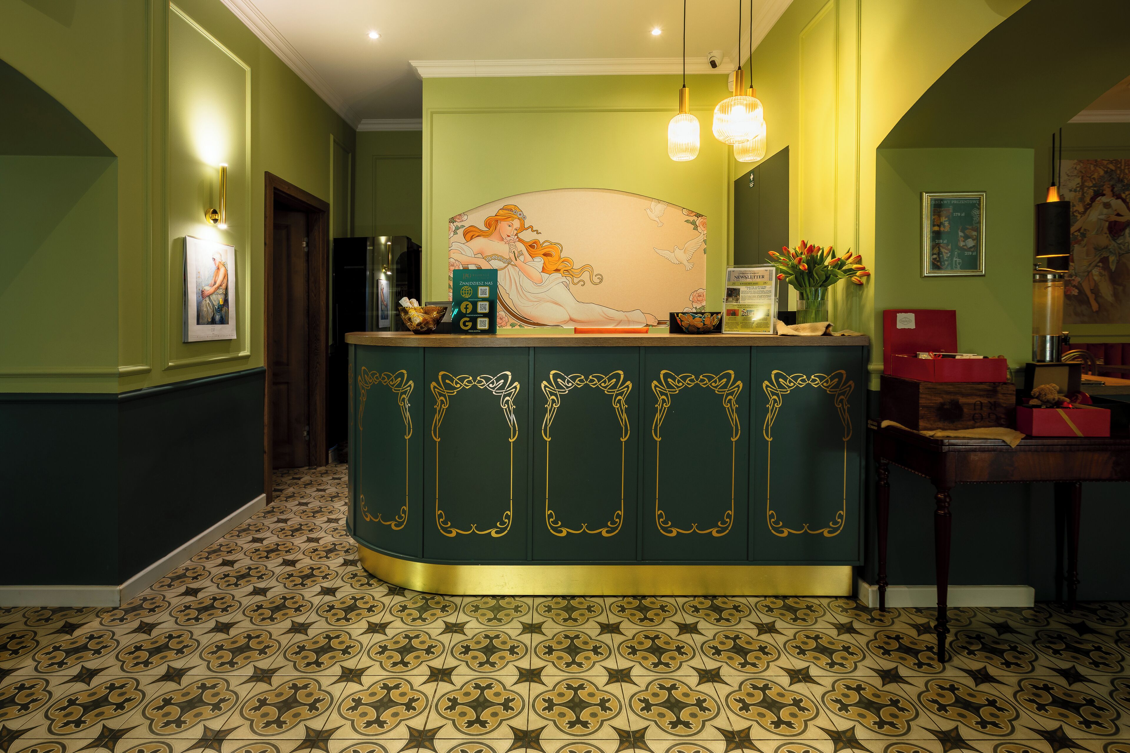 A reception area with a green wall, a decorative painting, and a patterned floor.