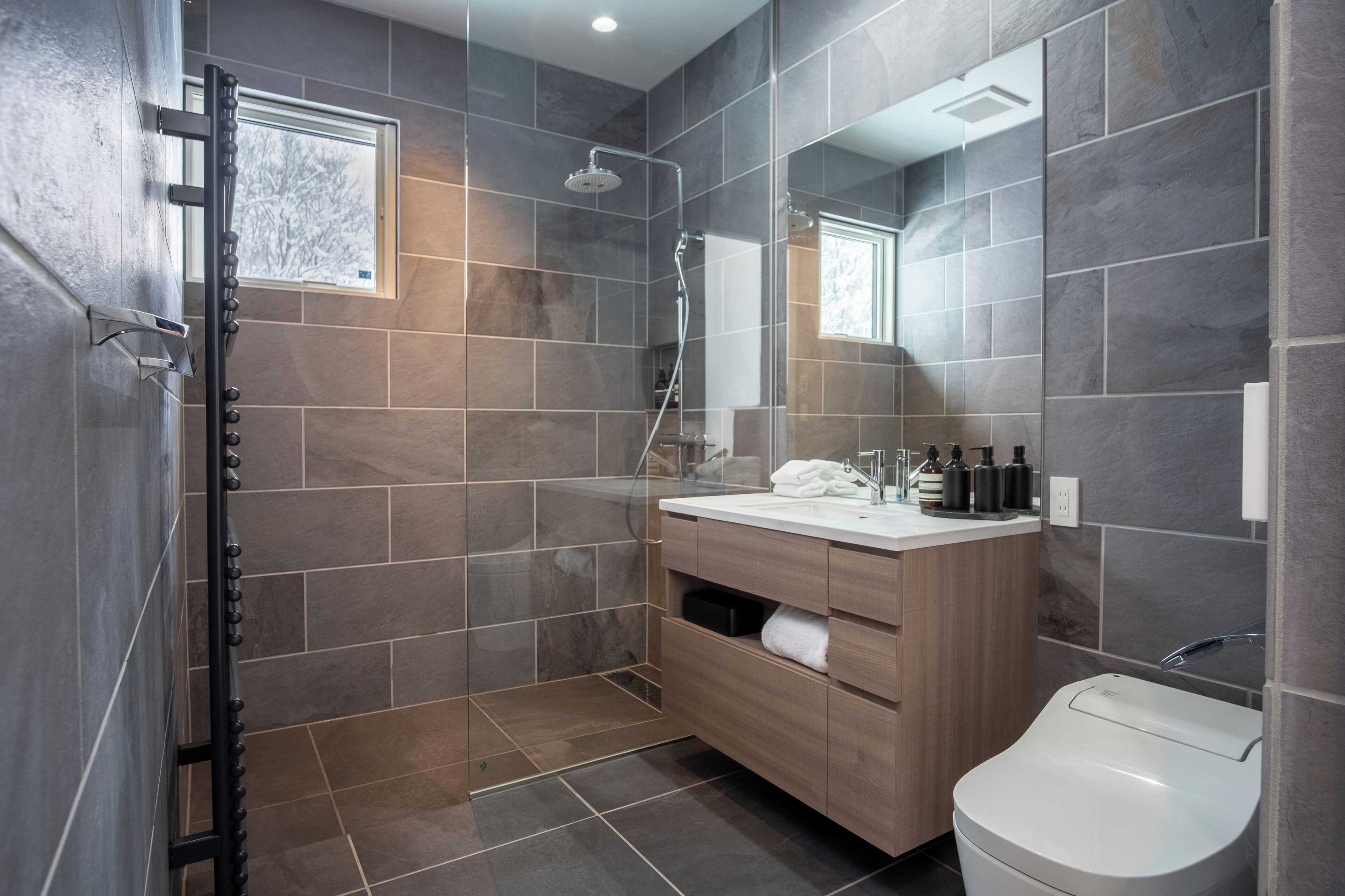 A modern bathroom with a shower, toilet, and vanity.