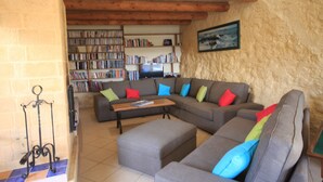 Una sala de estar con un sofá modular, una mesa de centro y una estantería llena de libros.