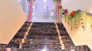 Un escalier en marbre orné de motifs floraux et doté d’une rampe en verre.