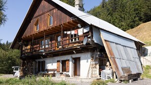 Una baita di legno con un balcone, un camino e un'antenna parabolica.