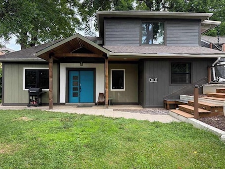 A two-story house with a blue front door, a small porch, and a number '2313' on the side.. Funky and fun, secret room, board games. Sleeps 5