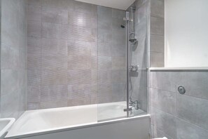 Bathtub, hair dryer, towels, shampoo