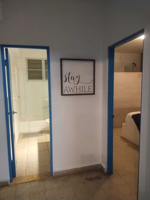 Een gang met een lijst waarop de tekst 'stay AWhile' staat.