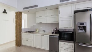 Een moderne keuken met witte kasten, roestvrijstalen apparatuur en een centraal eiland.