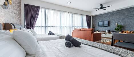 A modern hotel room with a large bed, two bedside tables, a desk, and a TV.