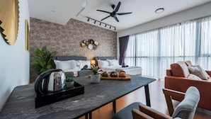 Una sala de estar moderna con un sofá, una mesa de centro y un comedor con hervidor y planta.