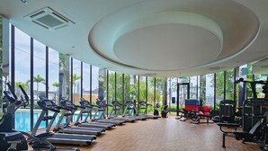 Un gimnasio con cintas de correr, bicicletas estáticas y máquinas de pesas.