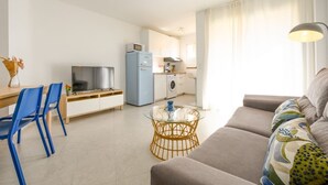 A modern apartment with a dining area, kitchen, and living room. - Terrace, swimming pool, parking (Fuengirola)