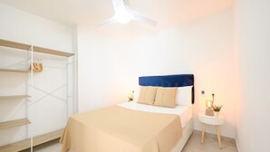 A bedroom with a bed, a nightstand, a ceiling fan, and a built-in shelving unit. - Terrace, swimming pool, parking (Fuengirola)