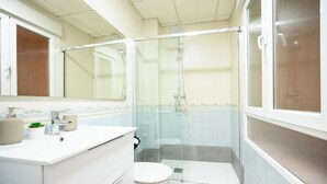 A modern bathroom with a glass-enclosed shower, a white sink with a mirror above it, and a toilet. - 2 min to the beach. Modern apartment (fuengirola)