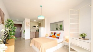 Un dormitorio moderno con cama, mesitas de noche, un armario y vistas a la cocina.
