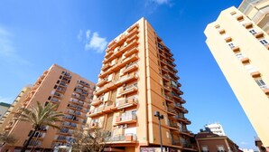 A multi-story residential building with balconies, a clear blue sky, and palm trees. - Sea & Mountain views from a 10th floor studio with terrace by 10ToSea (Fuengirola)