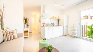 Un appartement moderne comprenant un espace de vie, une kitchenette et un balcon avec vue.