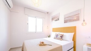 Une chambre à coucher avec un lit, une fenêtre et un climatiseur fixé au mur.