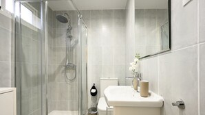 A modern bathroom with a glass-enclosed shower, a white sink, and a toilet. - Nice studio at 3min to the beach new refurbished by 10ToSea (Fuengirola)