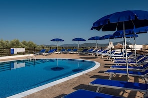 A pool area with blue umbrellas, sun loungers, and a clear view of the mountains in the background. - Beautiful Vista Blu Resort No2148 (Alghero)