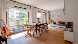 Un vaste espace de vie comprenant une table à manger, des chaises, un canapé et une guitare.