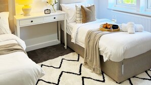 A bedroom with a bed, bedside table, lamp, and a window with a view. - 4 Beds House Coventry Sleep 7 With 3parking Spaces (Coventry)