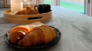 A breakfast setting with croissants, a bottle, and a glass on a tray. - 4 Beds House Coventry Sleep 7 With 3parking Spaces (Coventry)