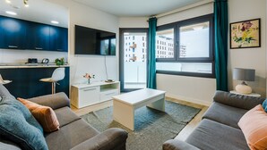 Un salon moderne avec un canapé, une table basse et un téléviseur fixé au mur.