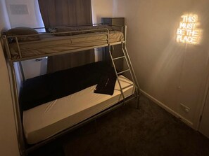 A bunk bed room with a neon sign stating "THIS MUST BE THE PLACE". - The Hideaway Home BD5 - 2 Bed Lovely Modern House (Bradford)