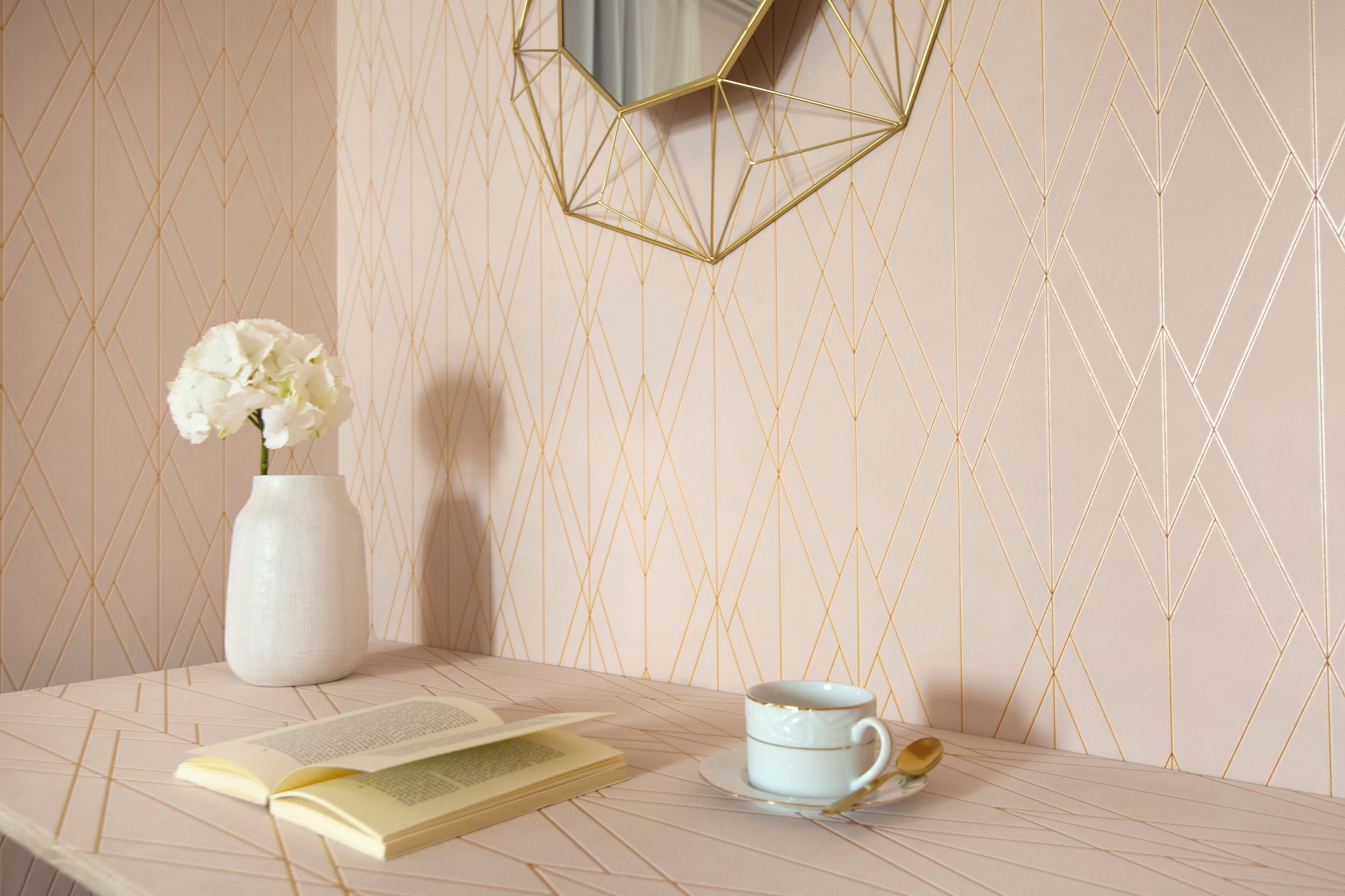 Ein Tisch mit einem Buch, einer weißen Vase mit einer Blume und einer weißen Tasse mit Untertasse.