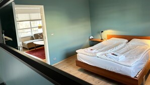 Ein Schlafzimmer mit einem Bett, einem Nachttisch, einer Lampe und einem Fenster mit Jalousien.