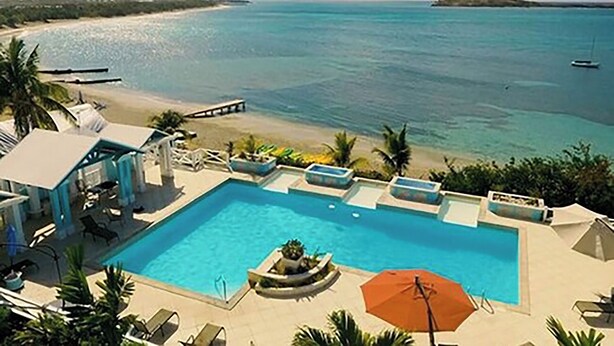 A pool area with a view of the beach and ocean. - Ocean Family Studio Bungalow (Christiansted)
