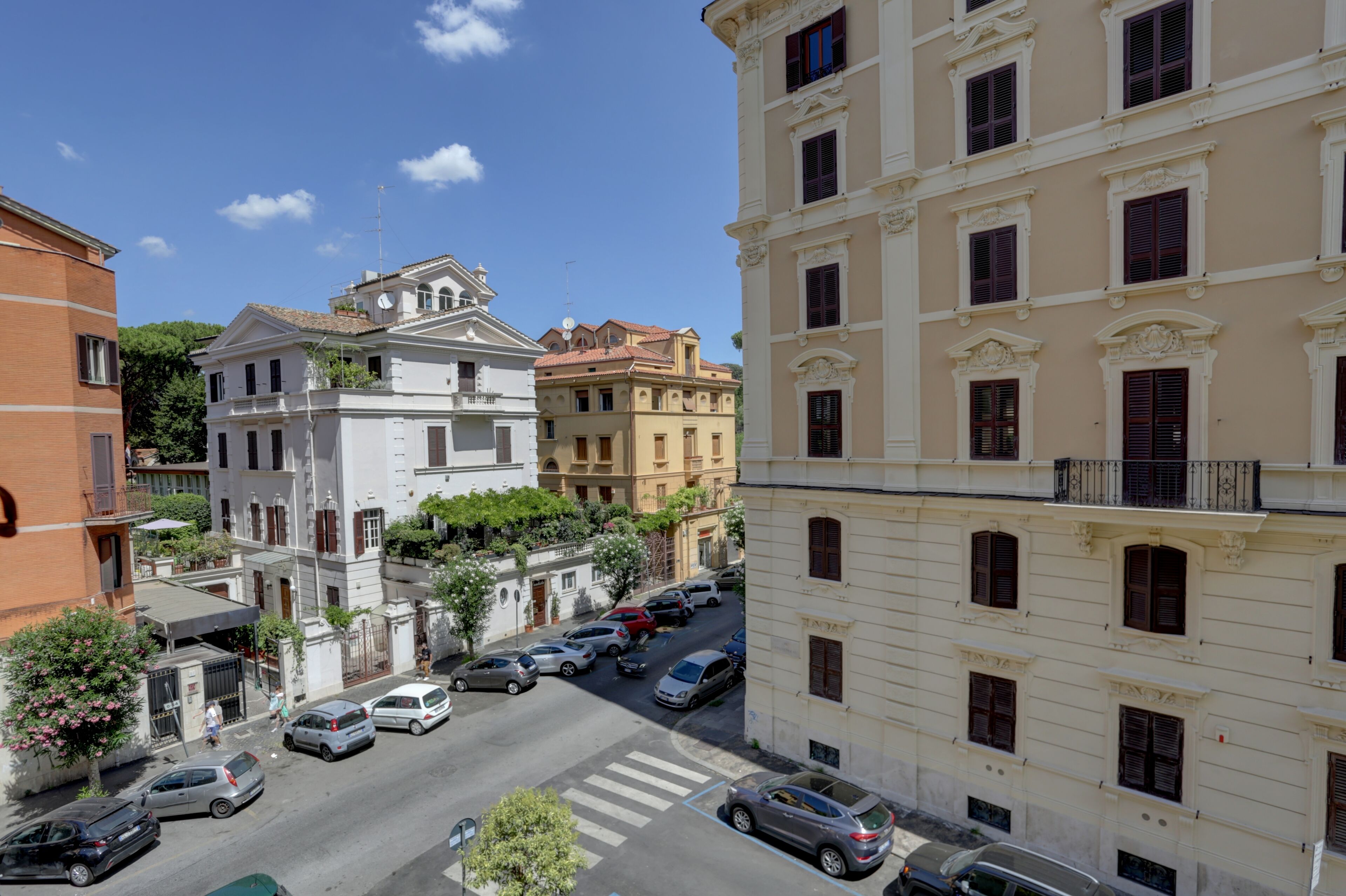 A street view of a city with historic buildings, a crosswalk, and parked cars.