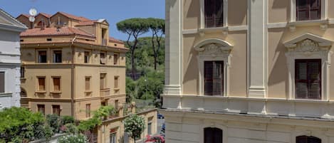 A street view of a historic building with classic architecture, including arched windows and decorative moldings.