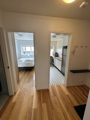 Ein Hotelzimmer mit Holzboden, einem Bett und Blick auf die Stadt.